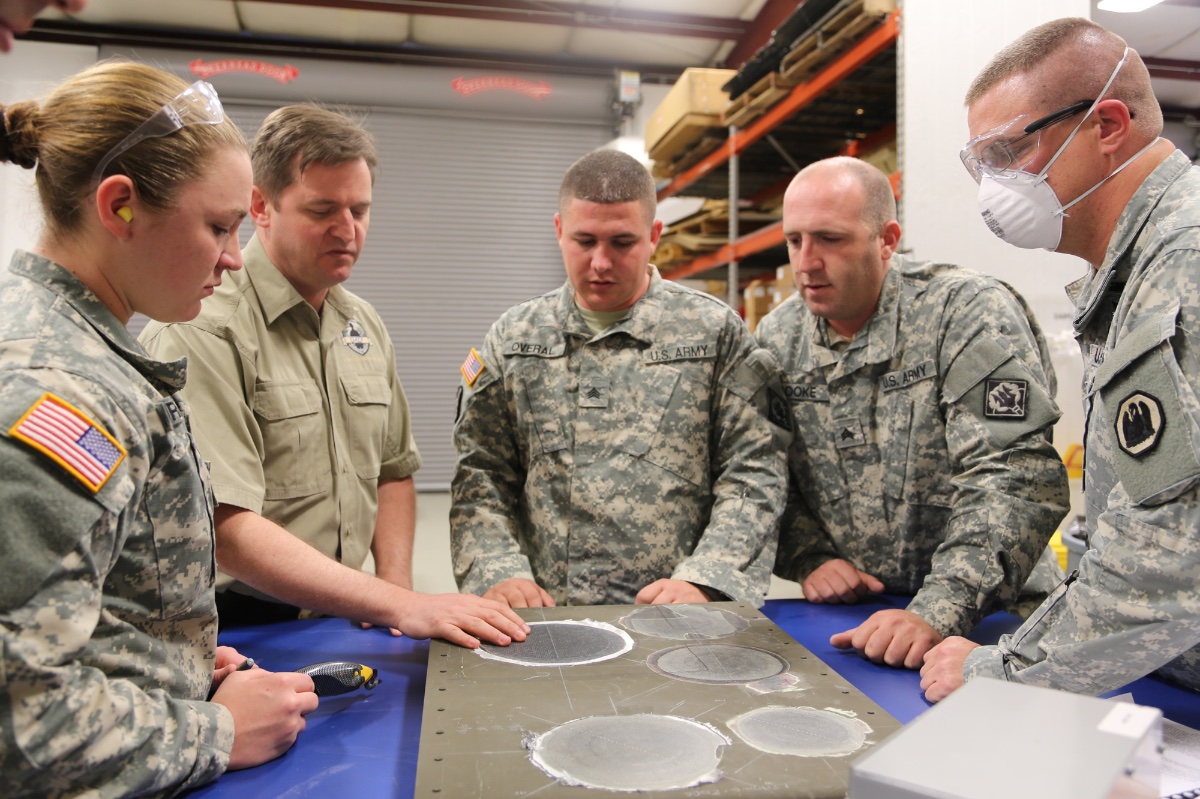 Earl Thomas, lead composite instructor, instructs National Guard Soldiers on inspecting a composite repair.